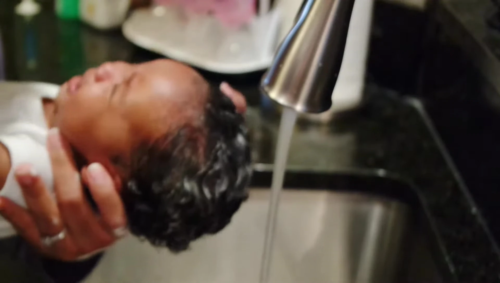 Rinsing the shampoo from baby's hair.