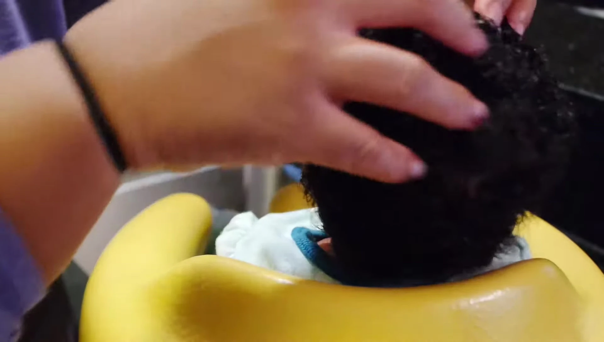 Combing the oil through baby's hair.