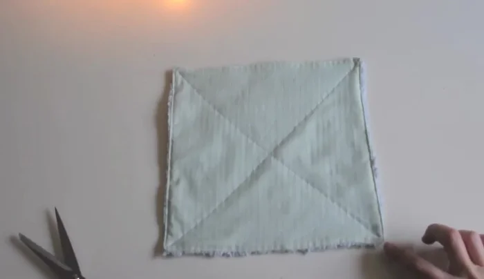 Create an 'X' in the center of the washcloth by quilting it to prevent the layers from separating. 