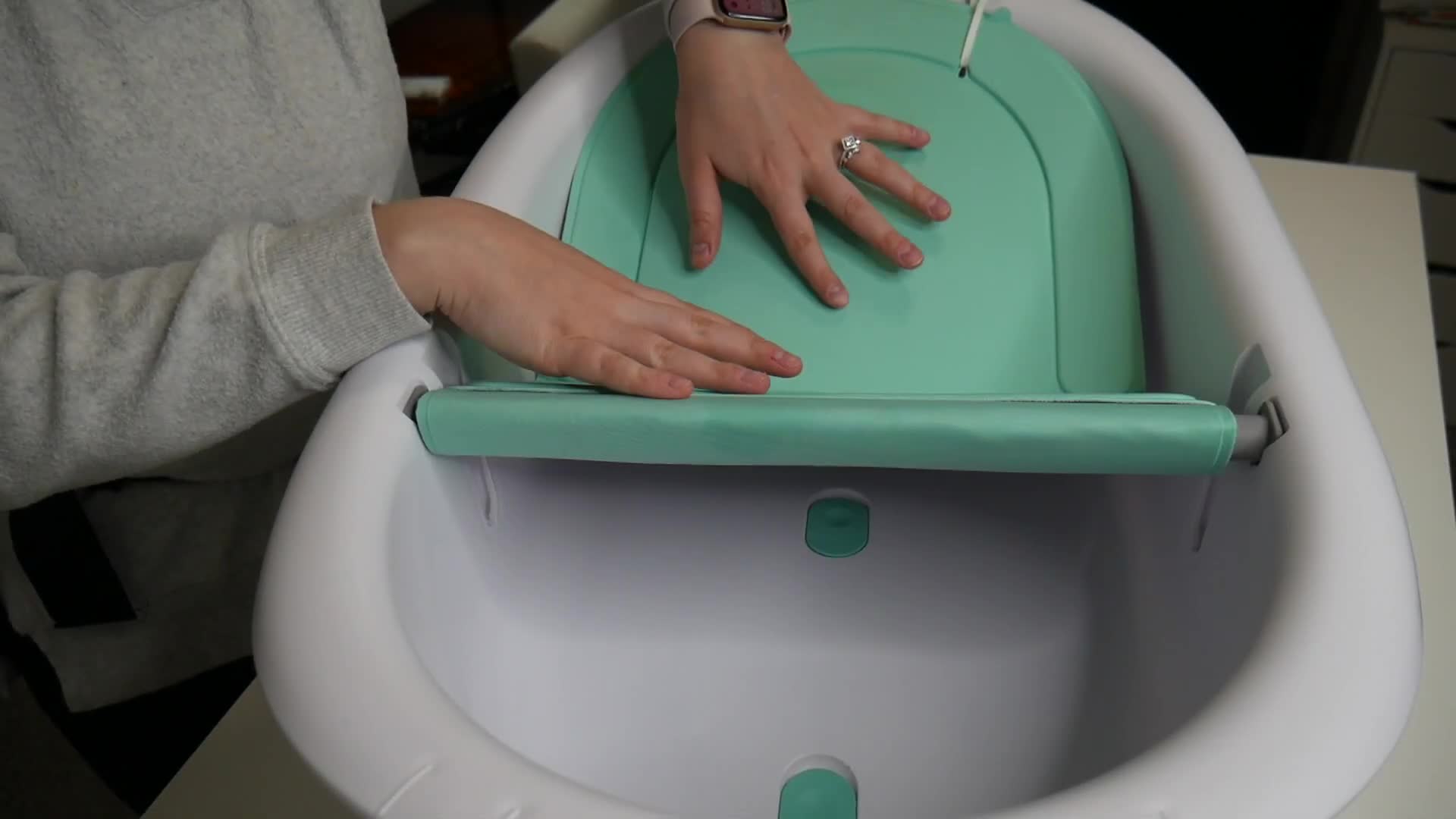 The green sling and white bathtub are clearly shown.