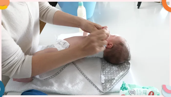 Undress your newborn and clean any messes (like poop) before placing them in the bath.