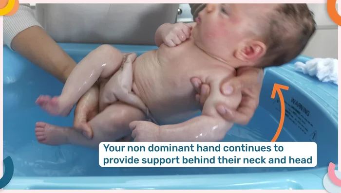 Lift your baby out of the bath, supporting their head and neck. Wrap them in a towel and dry thoroughly, paying attention to folds.