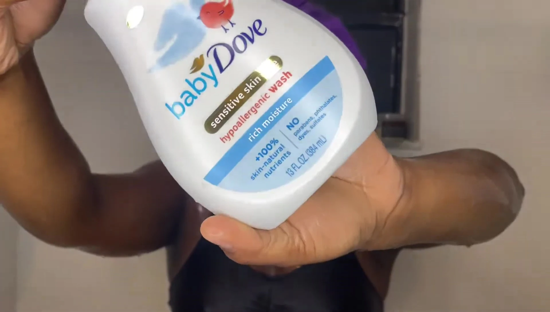 Close-up of the Dove Sensitive Skin wash bottle and silicone scrubber