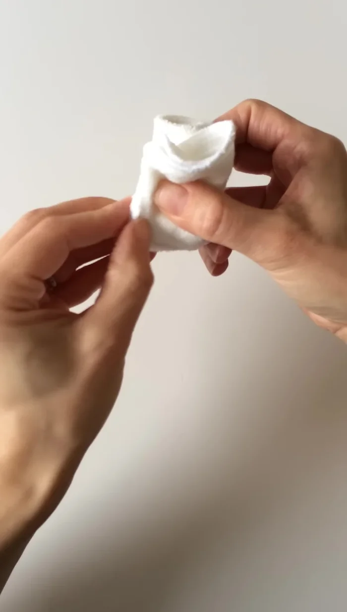 Turn and fold the back around to the front to secure the rosebud shape.