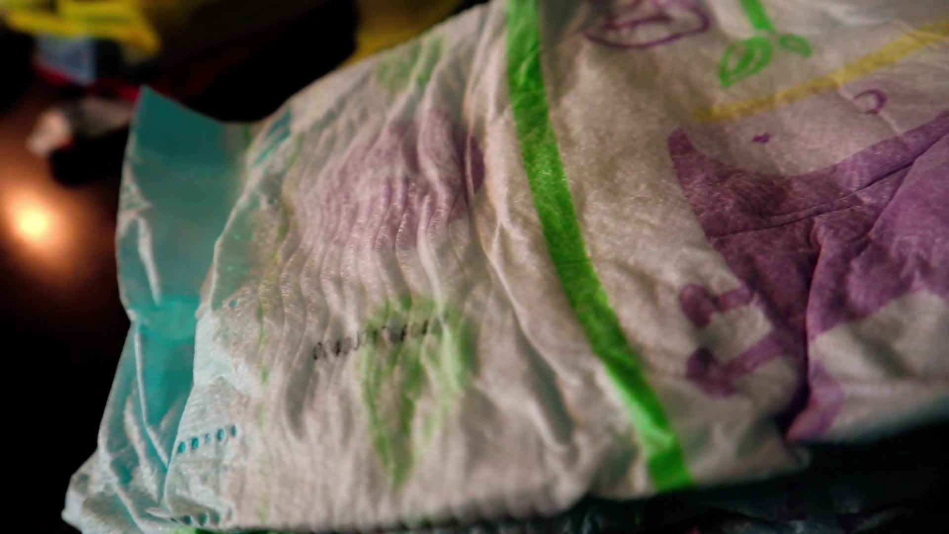 Close-up shot of diapers, washcloths, and onesies.
