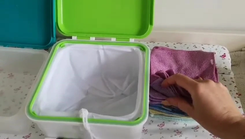 Adding wipes to the fresh wipes container.