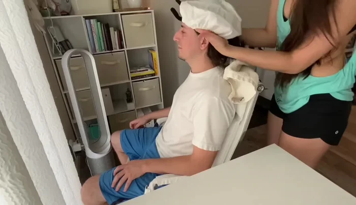 Place a towel behind the patient's neck and position the shower cap over their hair, ensuring it's fully sealed around the hairline.